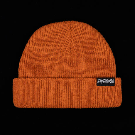 Rust orange beanie, back view with seam at crown and black logo patch