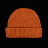 Rust orange knit beanie with ribbed cuff and smooth ribbed body