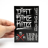 Hand holding sticker pack sheet with white graffiti lettering on black and red X
