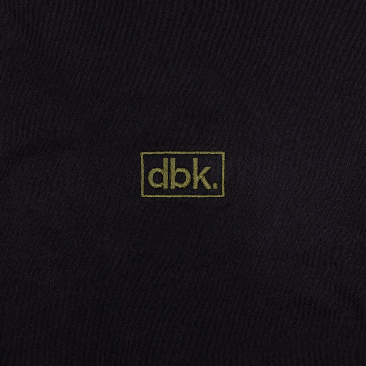 Black T-shirt fabric close-up with dbk logo patch