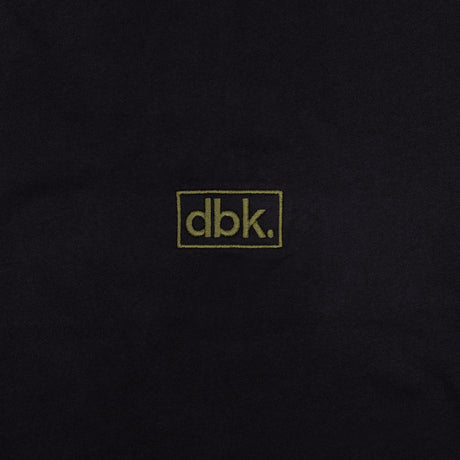 Black T-shirt fabric close-up with dbk logo patch