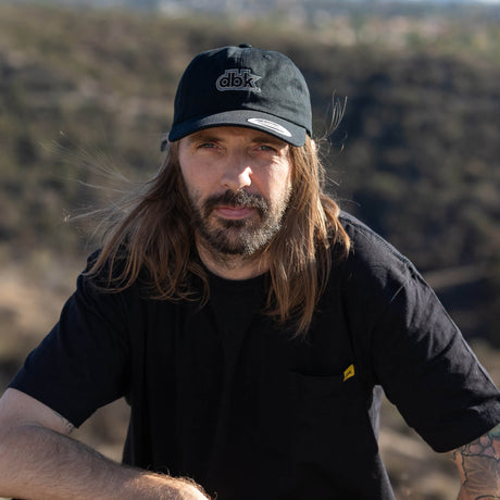Black dbk dad hat worn by model with front logo patch