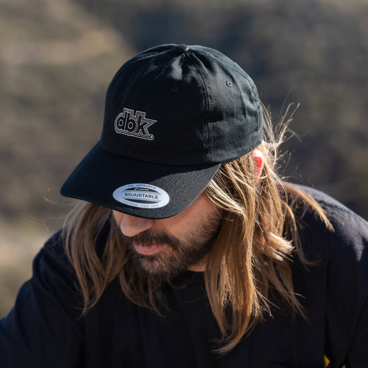 Black dad hat with dbk front logo and Adjustable label on brim