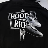 Close-up of black hoodie back print: HOOD RICH with sneaker graphic