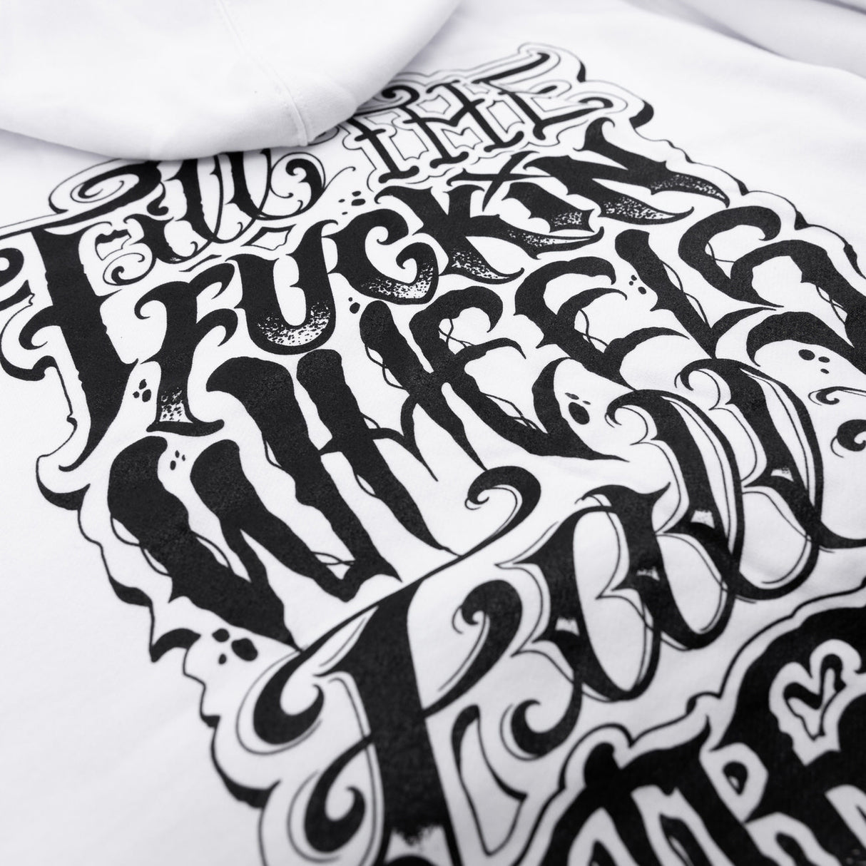 White hoodie fabric close-up with large black graphic lettering design.