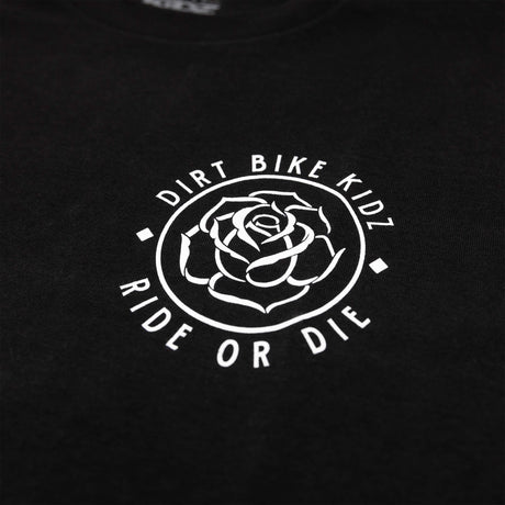 Close-up of black t-shirt chest logo: outlined rose in a circular badge