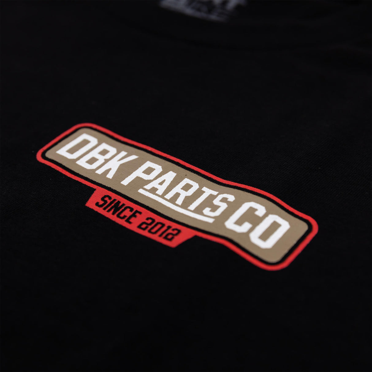 Black T-shirt close-up of DBK Parts Co. Since 2012 rectangular logo