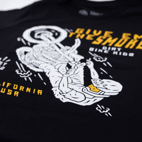 Close-up of black youth T-shirt front print with 'Give Em The Smoke' and rider graphic