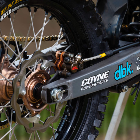 Motorcycle chain graphic on dark fabric with “dbk” logo
