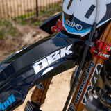 White racing wordmark decal on black front fender of a dirt bike
