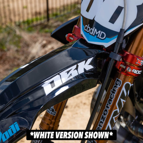 Black-and-white racer fender decal on a motorcycle side panel, angled close-up.