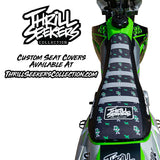 Custom motorcycle seat cover, black with green trim and repeating KL logo pattern