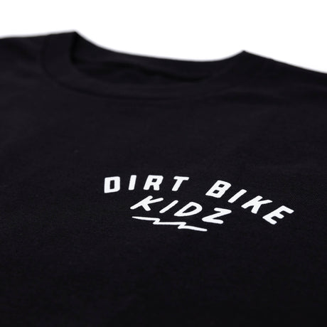Close-up of black kids T-shirt front chest graphic reading “DIRT BIKE KIDZ”