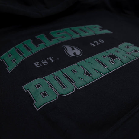 Close-up of green 'Burners' lettering and flame icon on black varsity hoodie