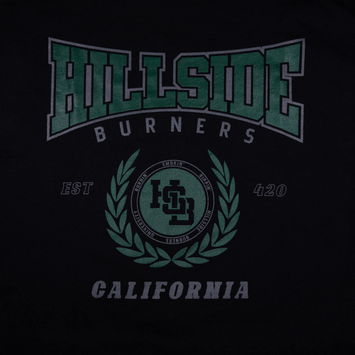 Black varsity tee close-up of green “Hillside Burners” front crest