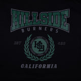 Black varsity tee close-up of green “Hillside Burners” front crest