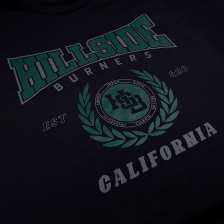 Black varsity tee close-up of green “Hillside” front logo and crest