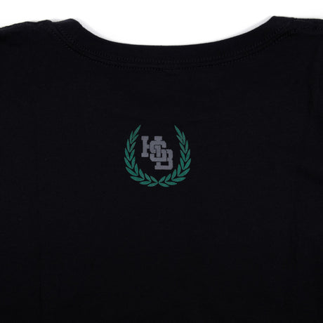 Black varsity tee with small green crest logo on chest