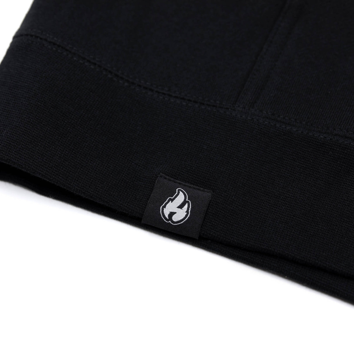 Black hoodie inner hem with small white flame logo woven label