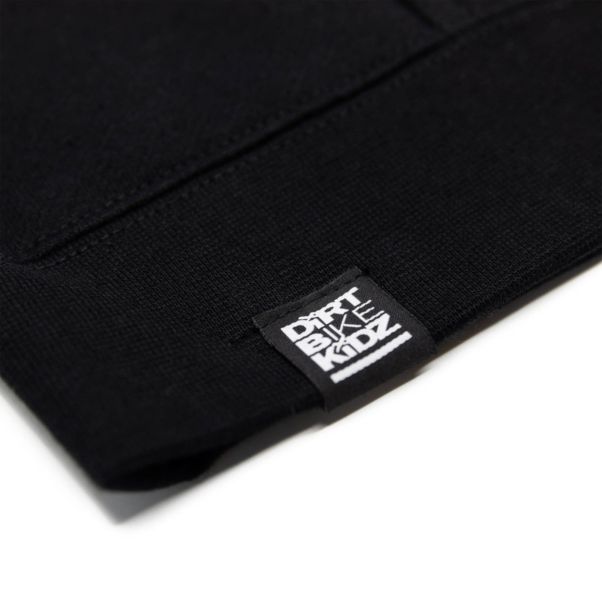 Black hoodie cuff close-up with woven brand label on sleeve hem.
