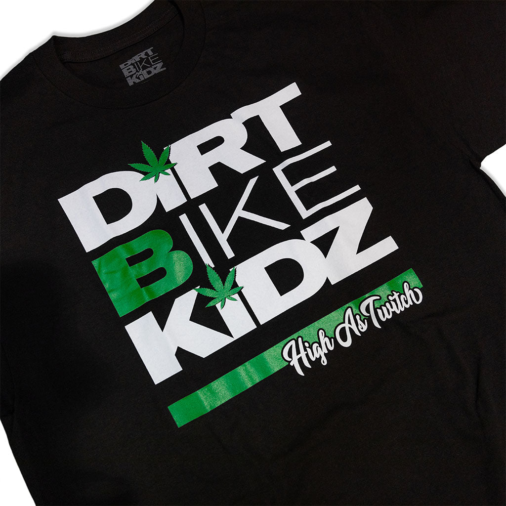 Black kids graphic T-shirt close-up of "Dirt Bike Kidz" text with green leaf icons