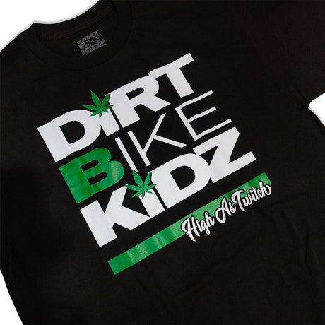 Black kids graphic T-shirt close-up of "Dirt Bike Kidz" text with green leaf icons