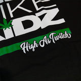 Black kids graphic T-shirt close-up of green stripe with "High As Truth" script
