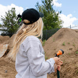 Black dad hat on blonde wearer from back with adjustable strap visible