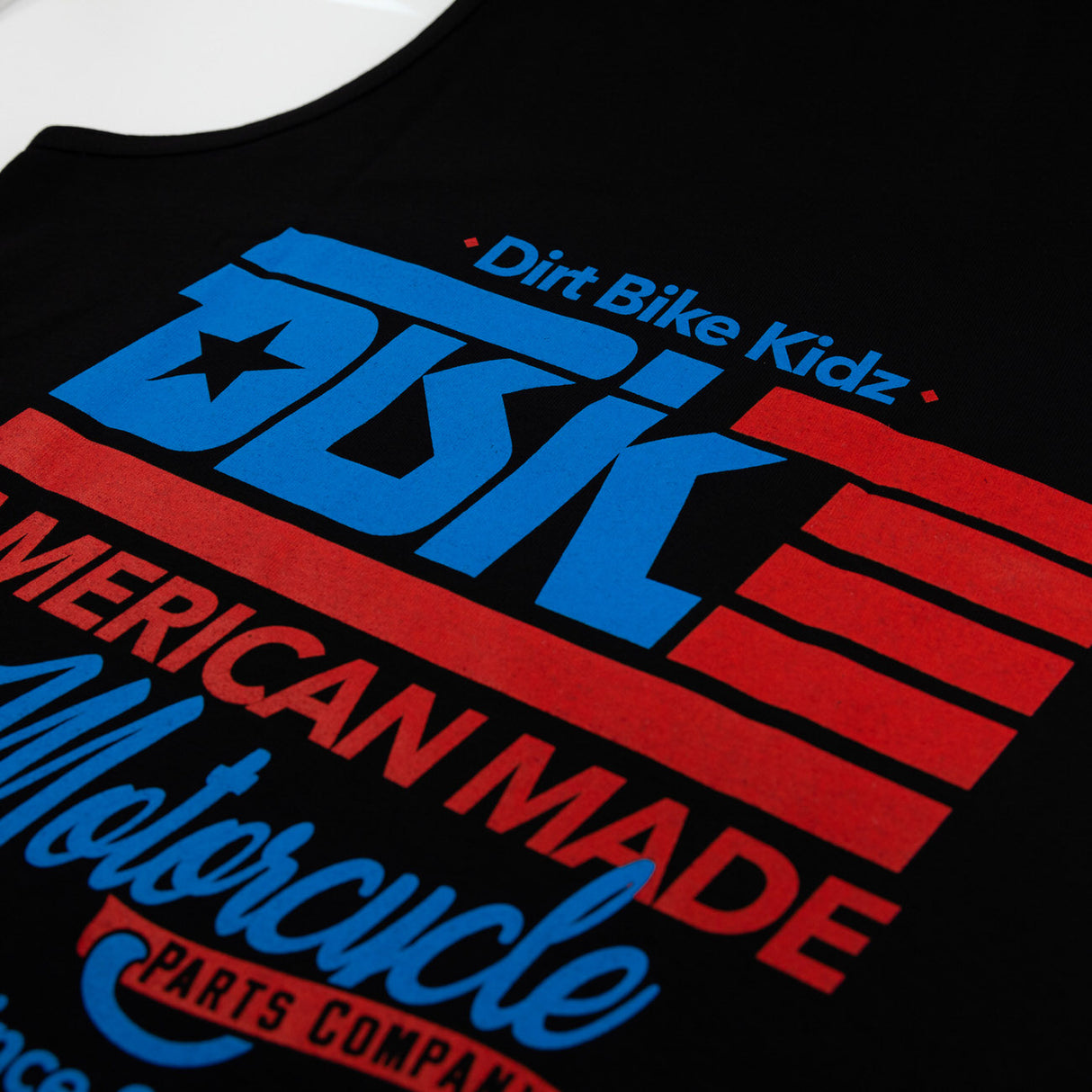 Black tank top graphic close-up with DBK, American Made, motorcycle text.