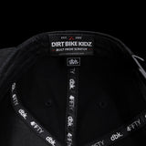 Black snapback cap interior with “DIRT BIKE KIDZ” label and dBK 4FITY trim