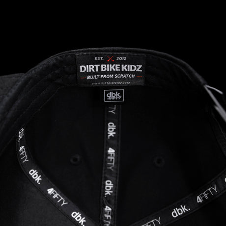 Black snapback cap interior with “DIRT BIKE KIDZ” label and dBK 4FITY trim