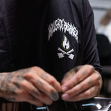 Black T-shirt close-up showing white flame icon and green flame lettering