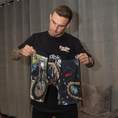 DBK underwear “Smoke” black boxer shorts with bike graphics, held up by model