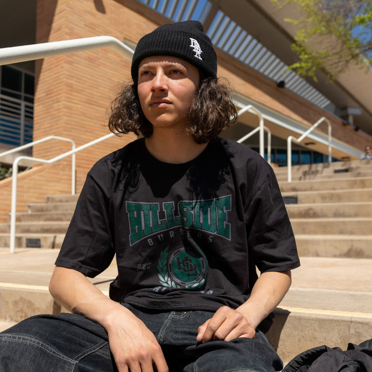 Black varsity tee worn by model with green “Hillside Burners” chest logo