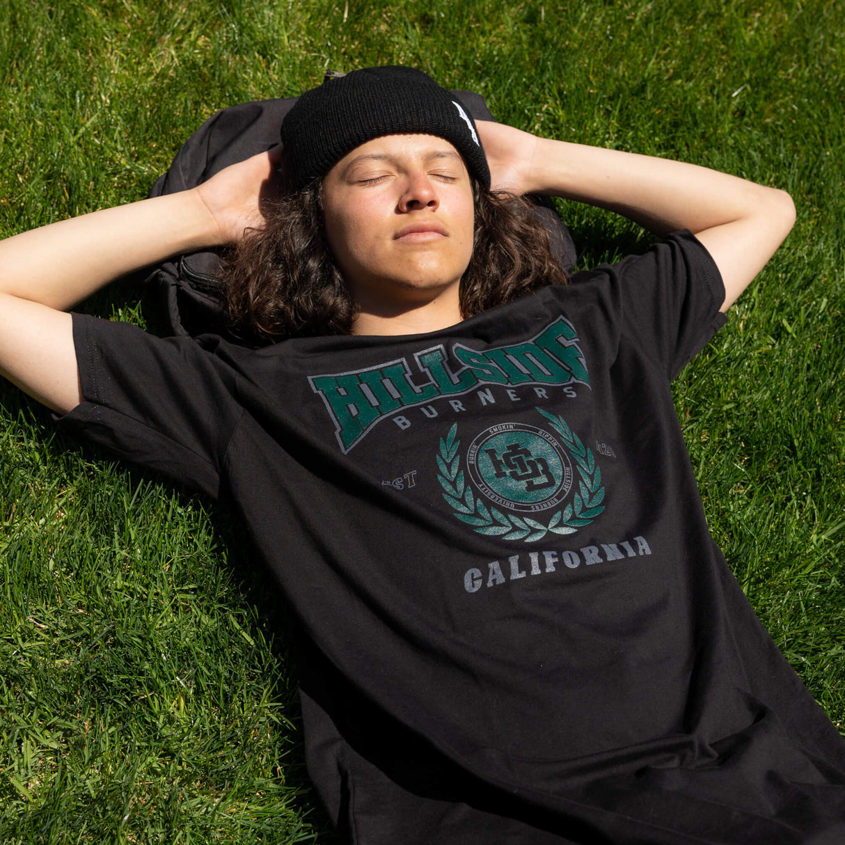Black varsity tee with green front crest and “California” text