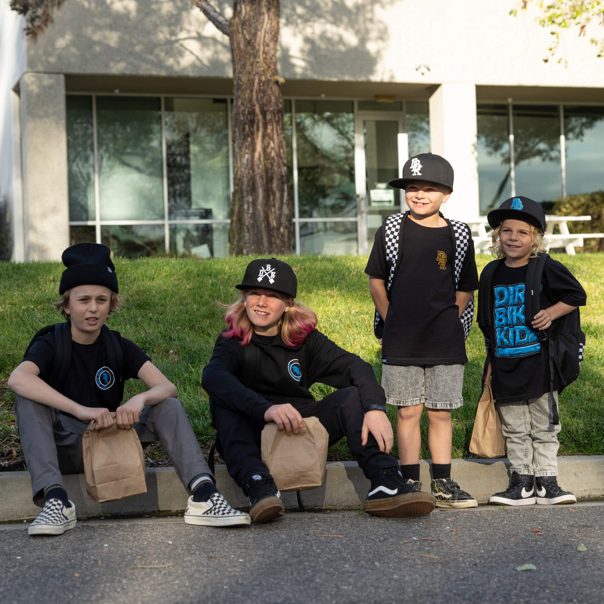 Children wearing black youth tee with blue “DIRT BIKE KIDZ” front graphic