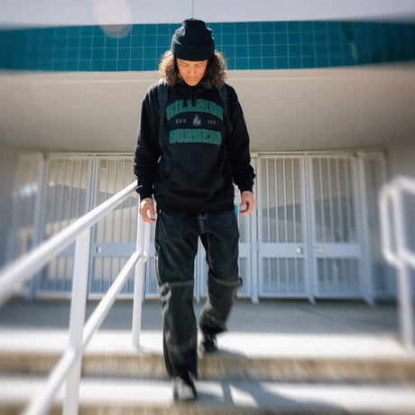 Black varsity hoodie with green logo print, front kangaroo pocket and drawstring hood