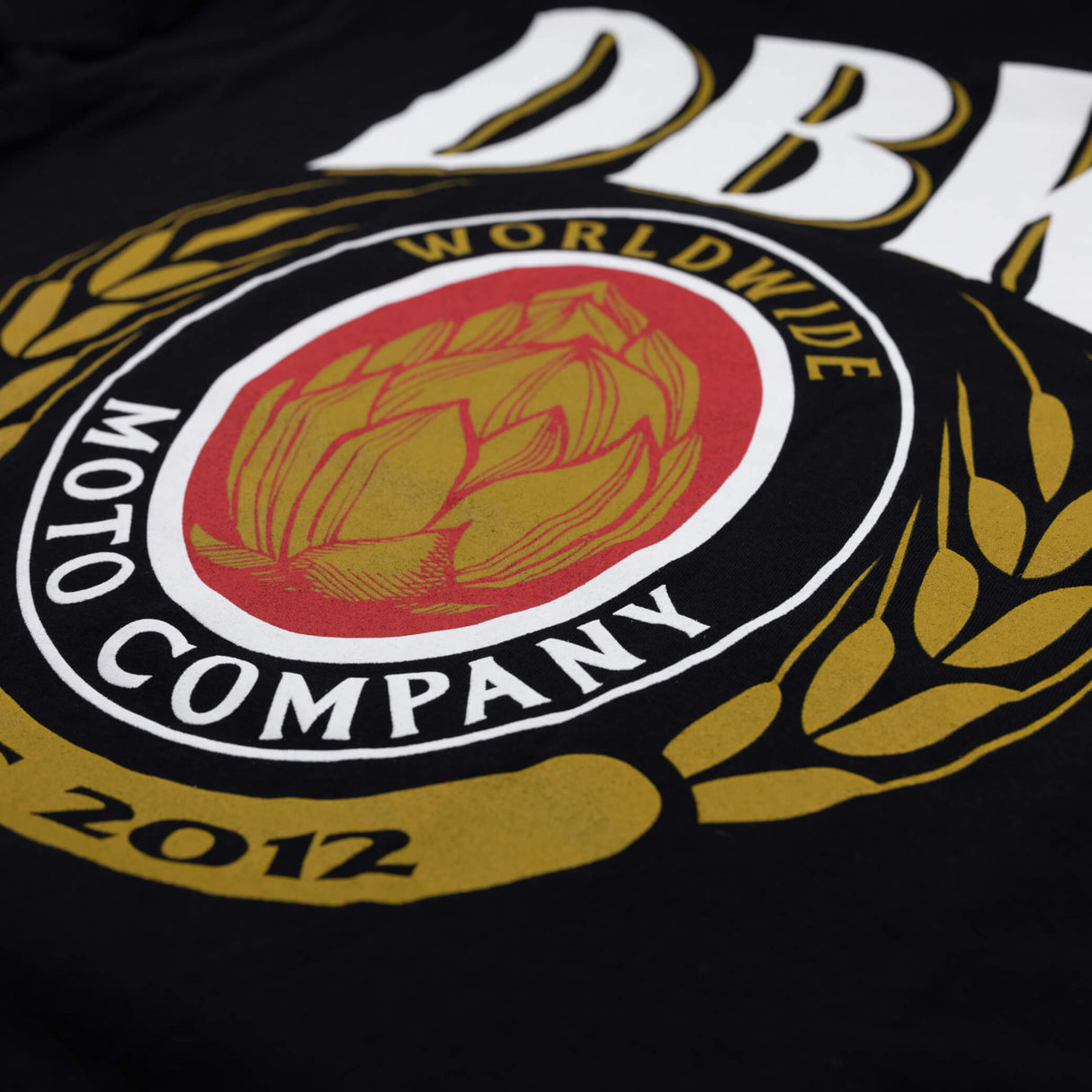 DBK Premium Tall Tee, black, close-up of World Wide Moto Company crest