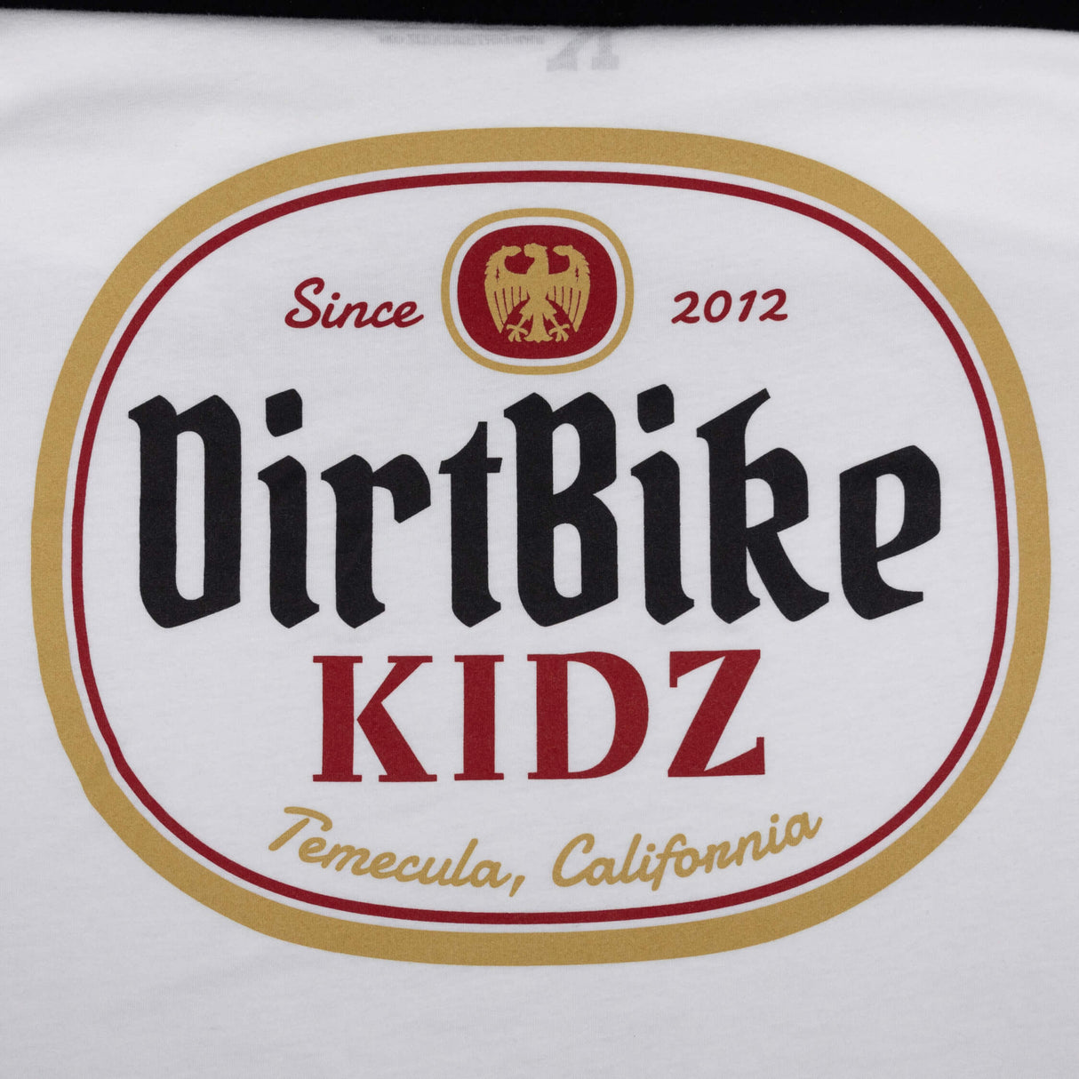 Premium tall tee logo close-up, white fabric with DirtBike KIDZ oval graphic