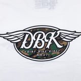 White tall tee close-up with large winged DBK emblem and camo-style graphic center