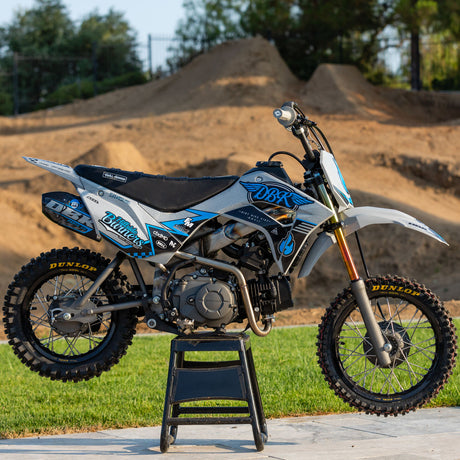 Motocross dirt bike with blue, white, and black decal graphics on full bike view