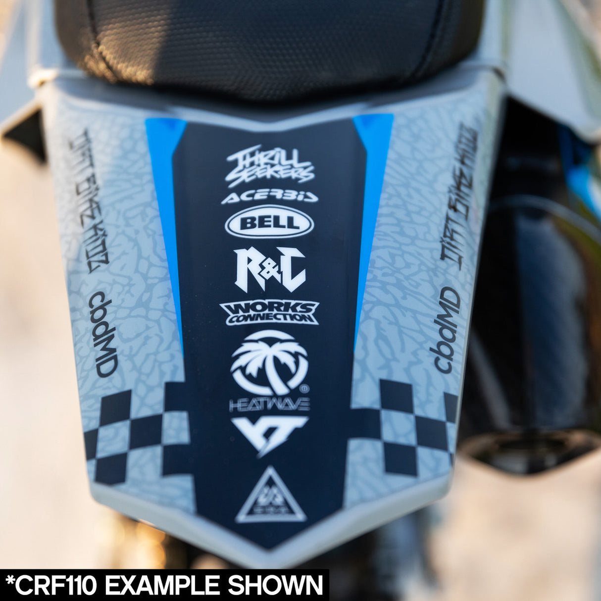 Front plate close-up with gray and blue branding logos on dirt bike graphics kit