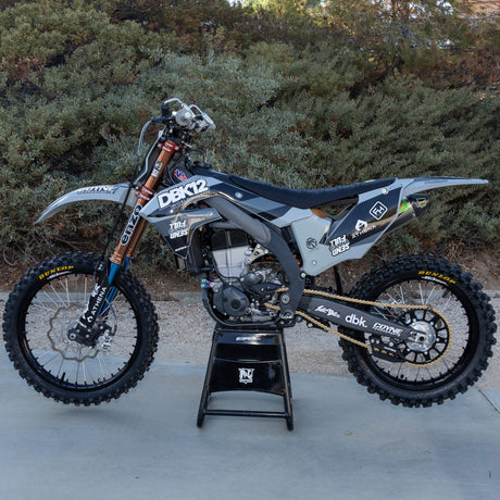DBK12 Twitch Edition gray dirt bike side view on a stand with knobby tires
