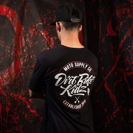 Black tall tee worn from the back with large circular graphic print