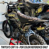 Close-up of KLX 110 graphics on black seat and side shrouds with yellow details