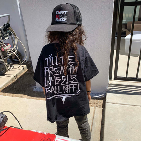 Youth premium tee in black with large white back graphic, worn by child