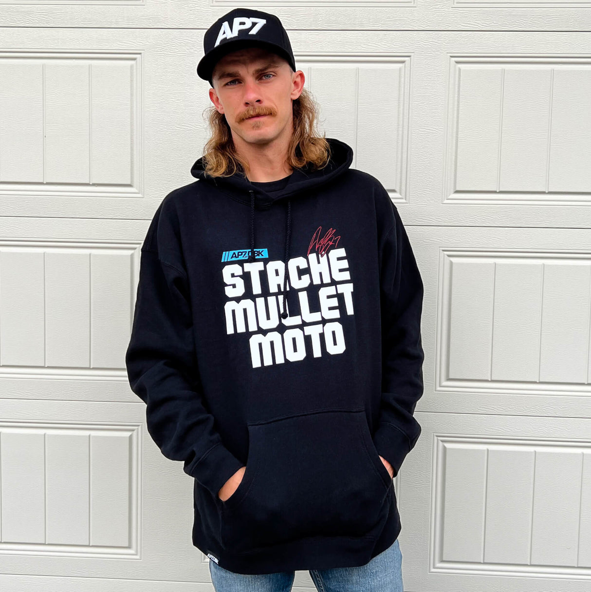 Navy pullover hoodie on model, with STACHE MULLET MOTO front text graphic