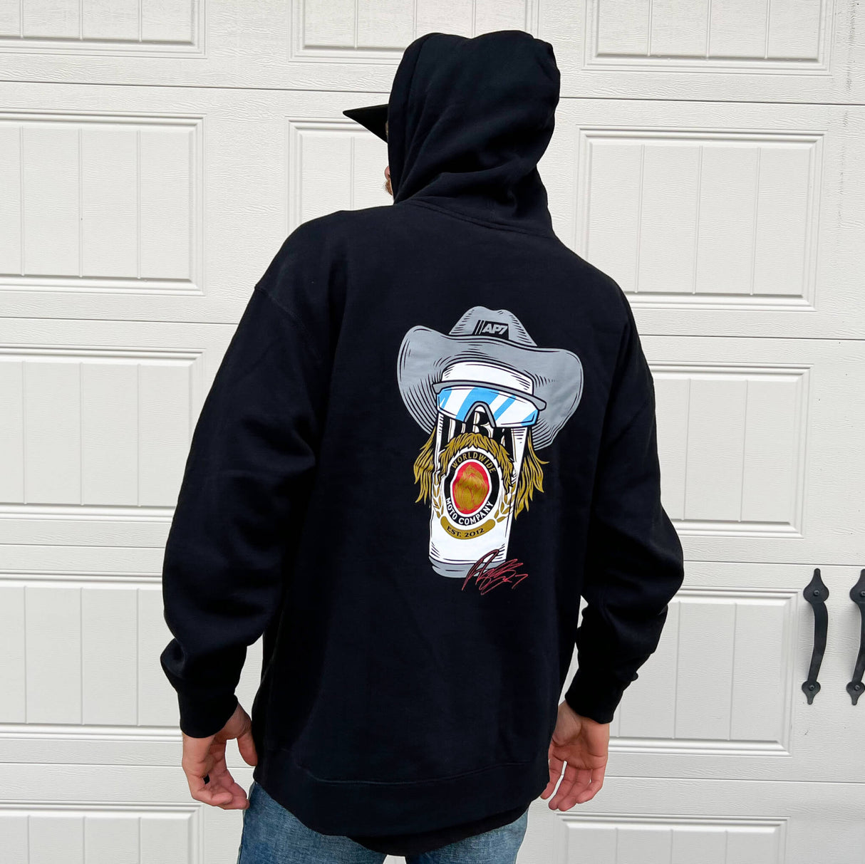 Navy pullover hoodie on model, with moto face and goggles graphic on back