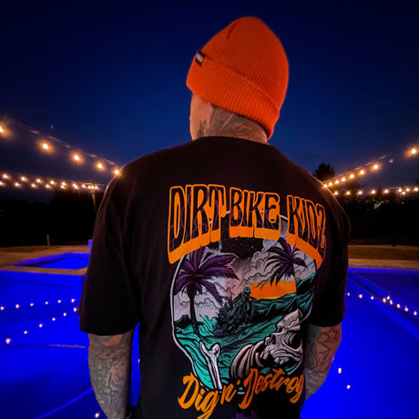 Rust orange beanie on head, folded cuff with small logo patch