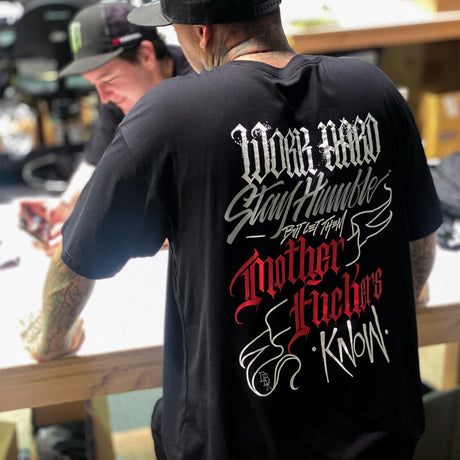 Black graphic tee worn by model, large back text and wings print